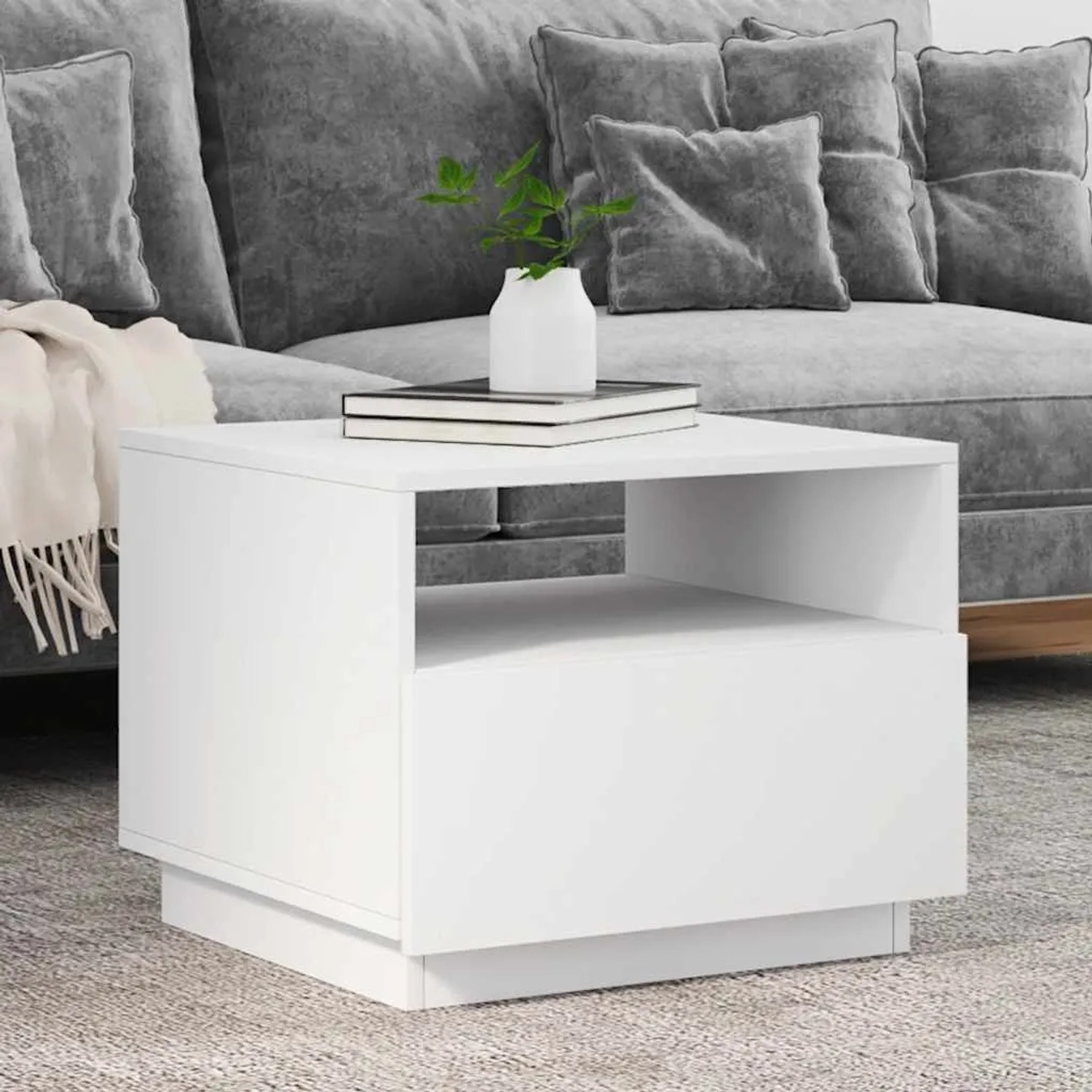 Weißer Couchtisch aus Holzwerkstoff mit offenem Fach, modernem Design und LED-Beleuchtung, dekoriert im Wohnzimmer.