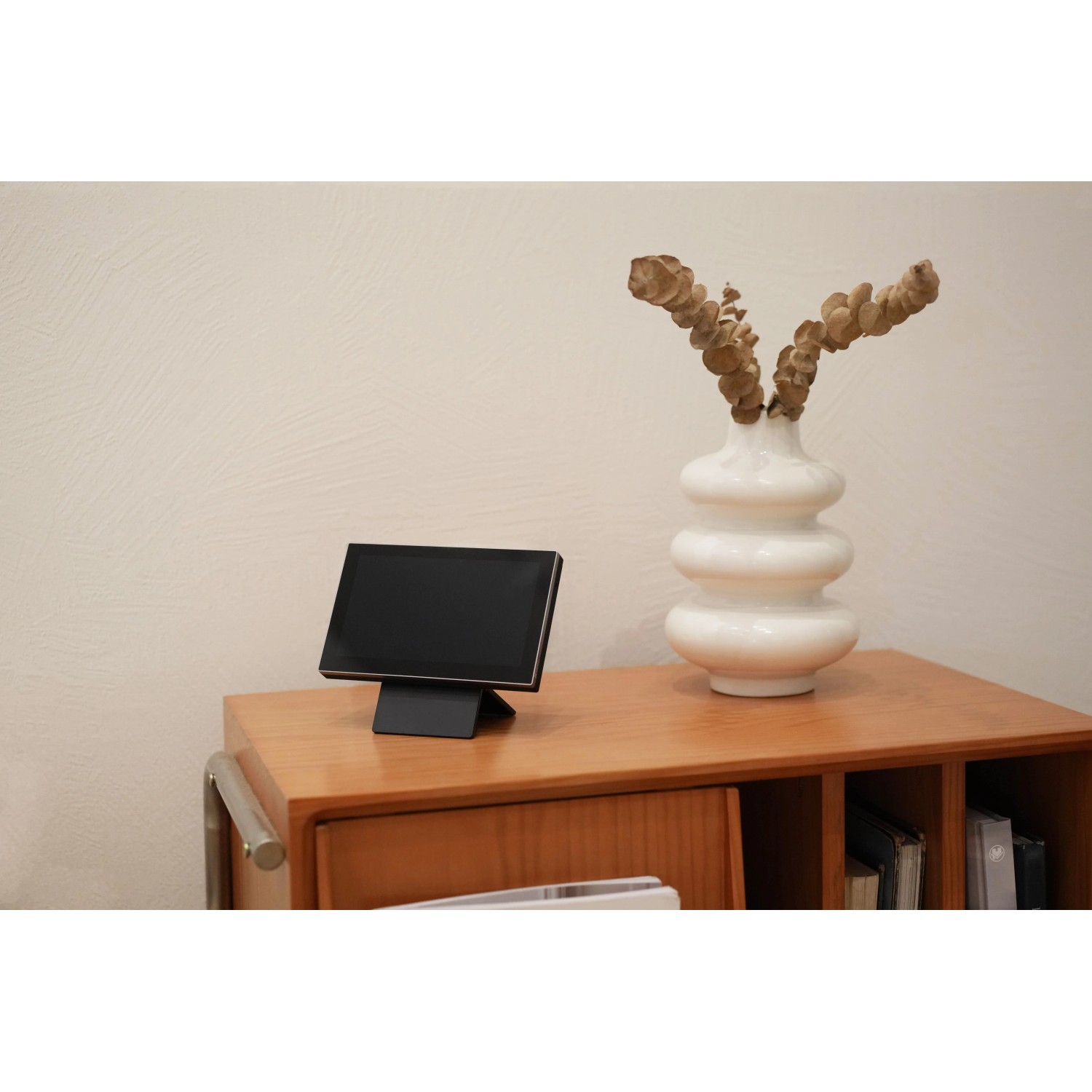 Ezviz Monitor mit Akku (17,78 cm) zur Kameraüberwachung, stehend auf einem Holzschrank.