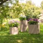 Lechuza Canto Stone Pflanzsäulen, sandbeige, mit bunten Blumen bepflanzt im Garten.
