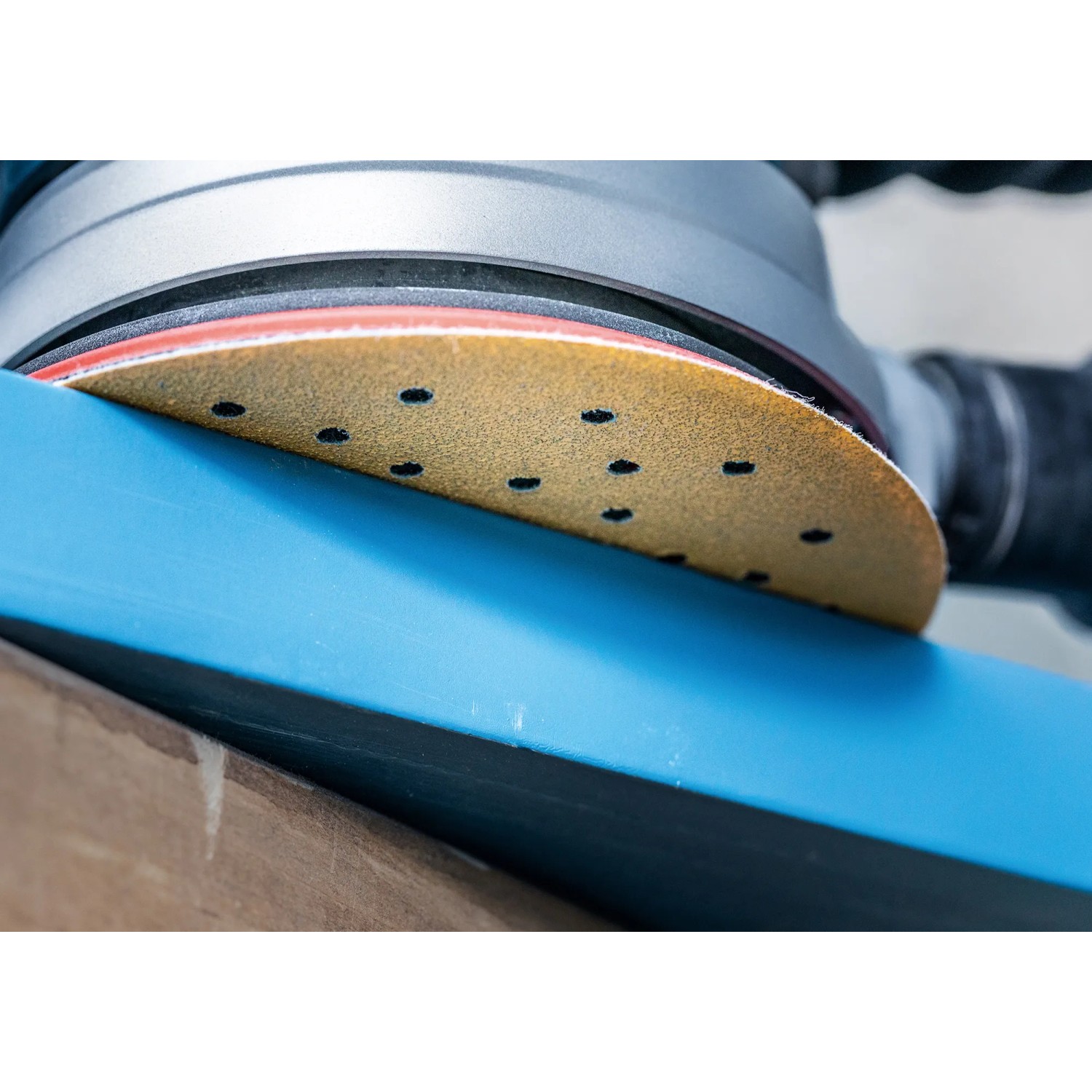 Bosch Expert Schleifblatt C470 K320, Ø 125mm, im Einsatz auf blau lackiertem Holz.