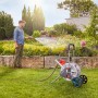 Gardena CleverRoll M Metall Schlauchwagen mit Mann beim Bewässern des Gartens.