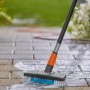 Gardena Cleansystem Stielbürste Hard in Aktion: Pflasterreinigung mit Wasser und Bürste.