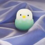 Grünes MegaLight LED-Nachtlicht Baby Eggy mit Akku auf blauem Stoff.