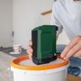 Bosch UniversalSpeaker 18V-1 Akku-Bluetooth-Box in Grün, per USB-C verbunden, auf Farbeimer in Arbeitsumgebung.