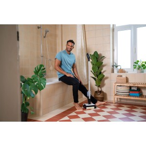 Kärcher Akku-Hartbodenreiniger FC 2-4 in Weiß-Schwarz im Badezimmer mit Mann.