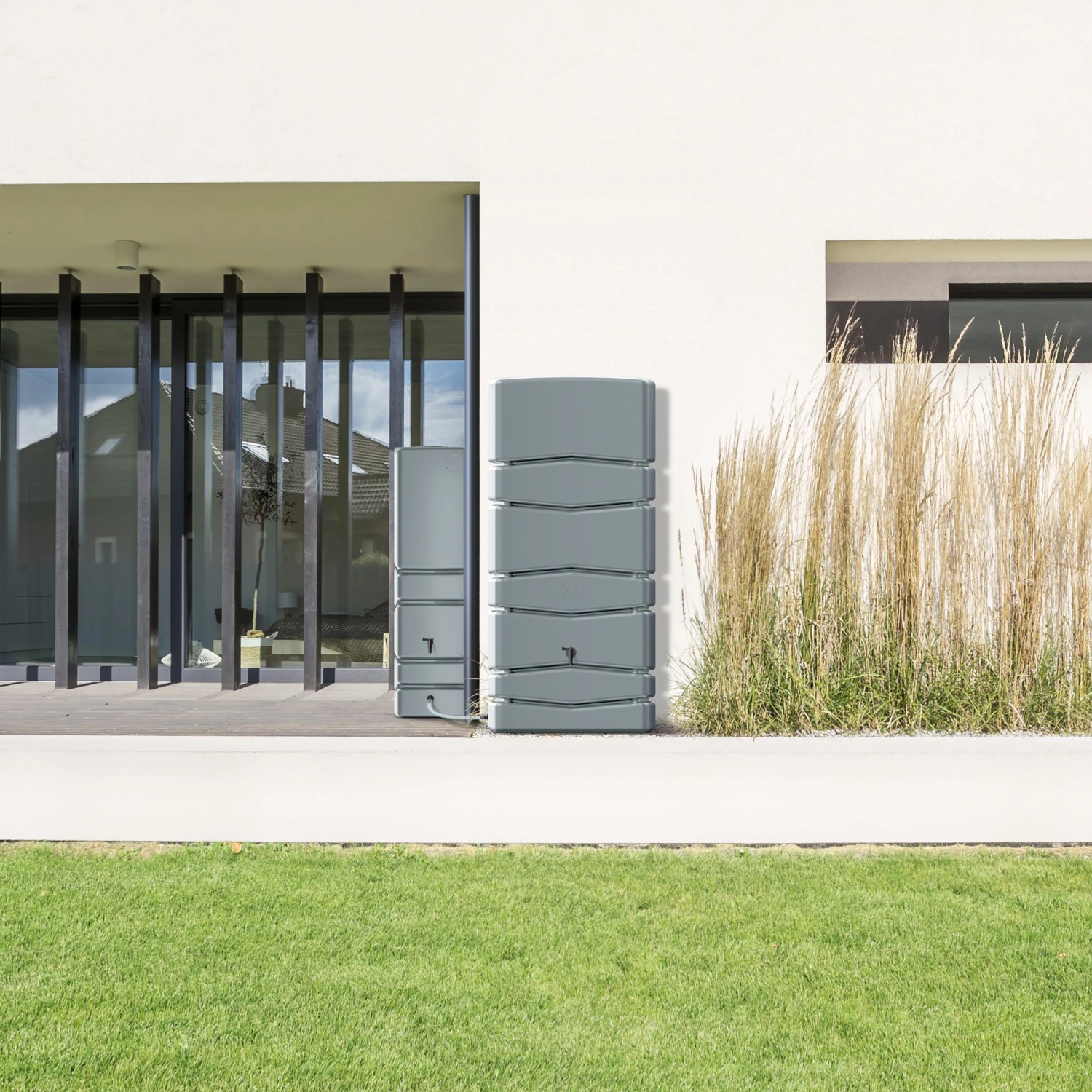 Graue Waterform Regentonne Aqua Tower 650 l vor Hauswand. Regenspeicher für Gartenbewässerung.
