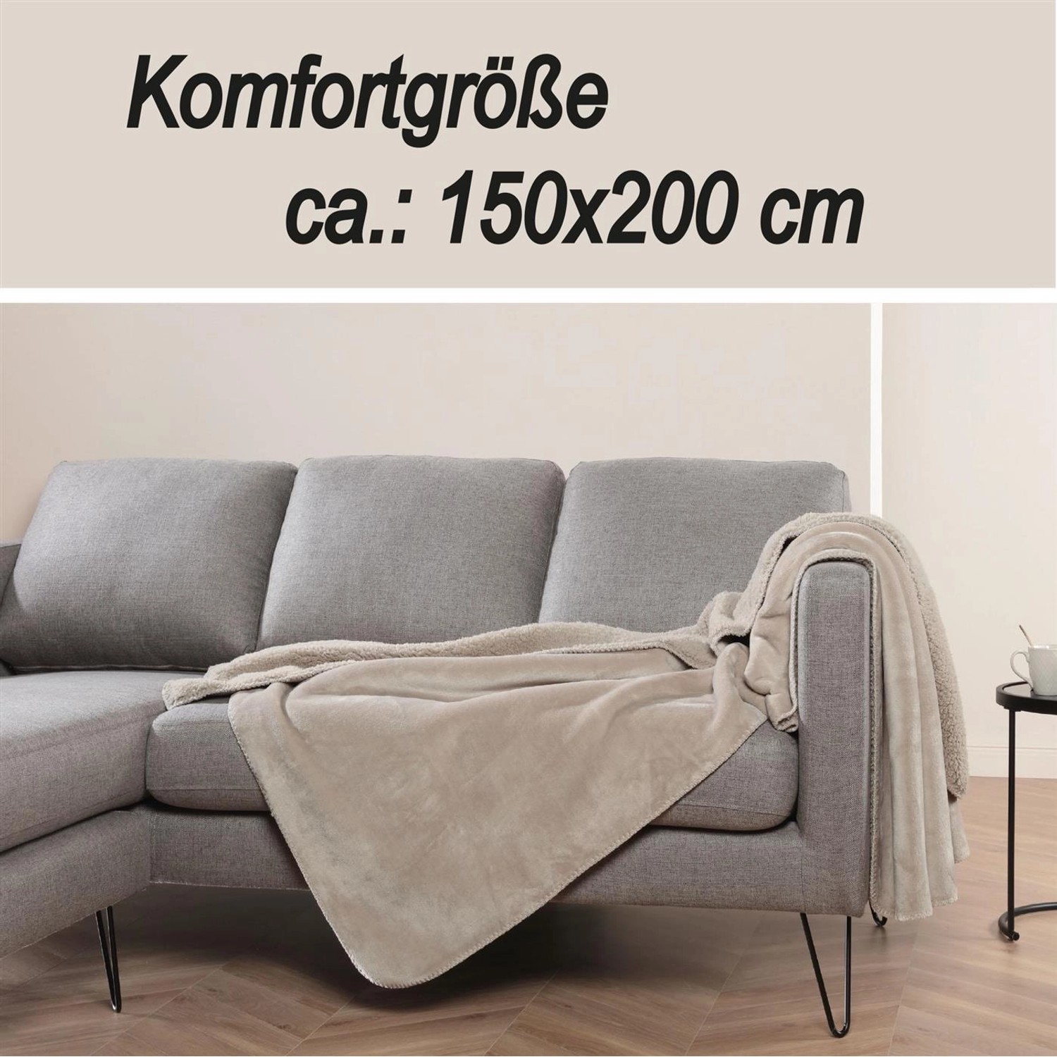 Beige Kuscheldecke (150x200 cm) aus Teddy Fleece und Sherpa auf grauem Sofa.