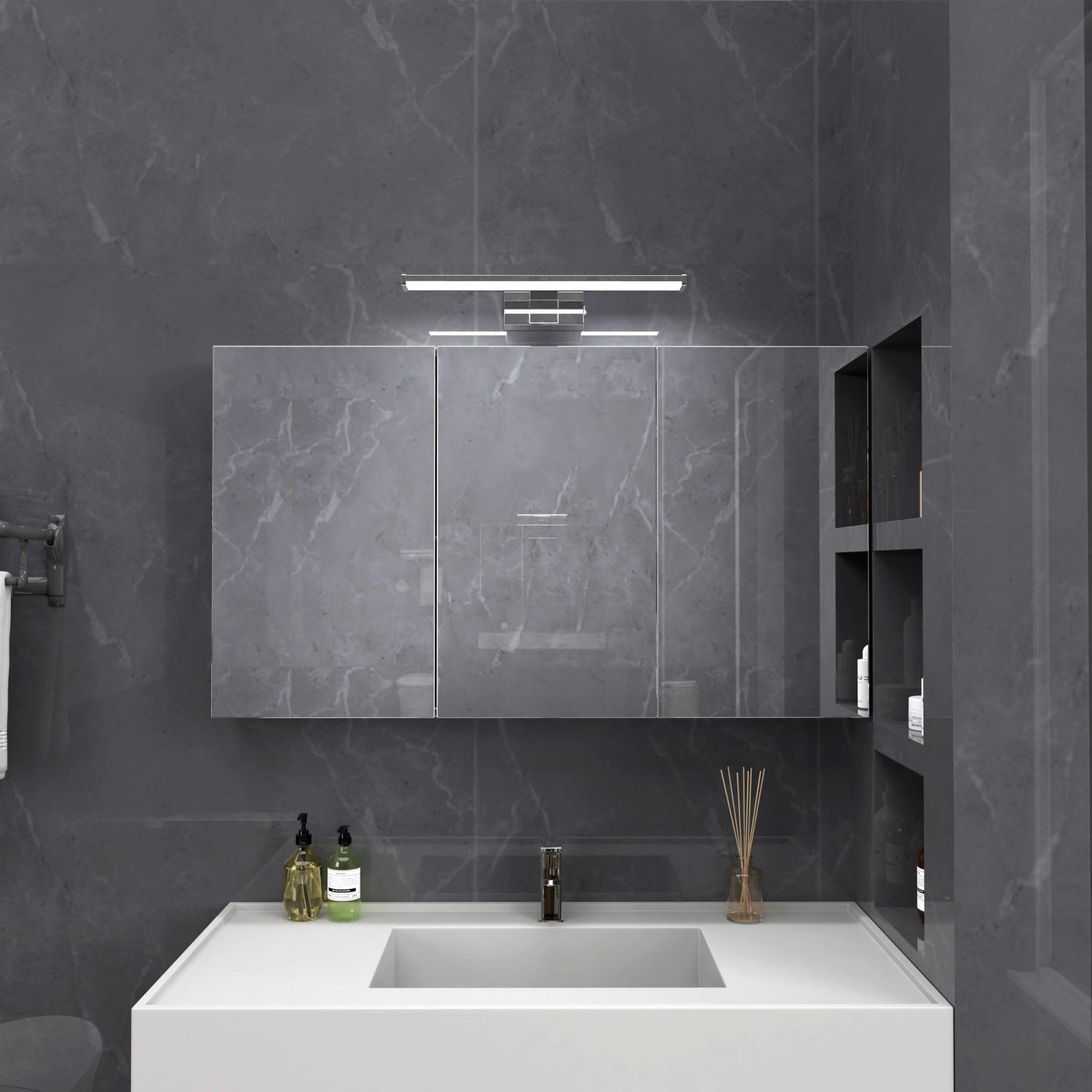 Chromfarbene kalb Wandlampe 500mm als Badleuchte über einem Waschbecken mit Spiegelschrank.