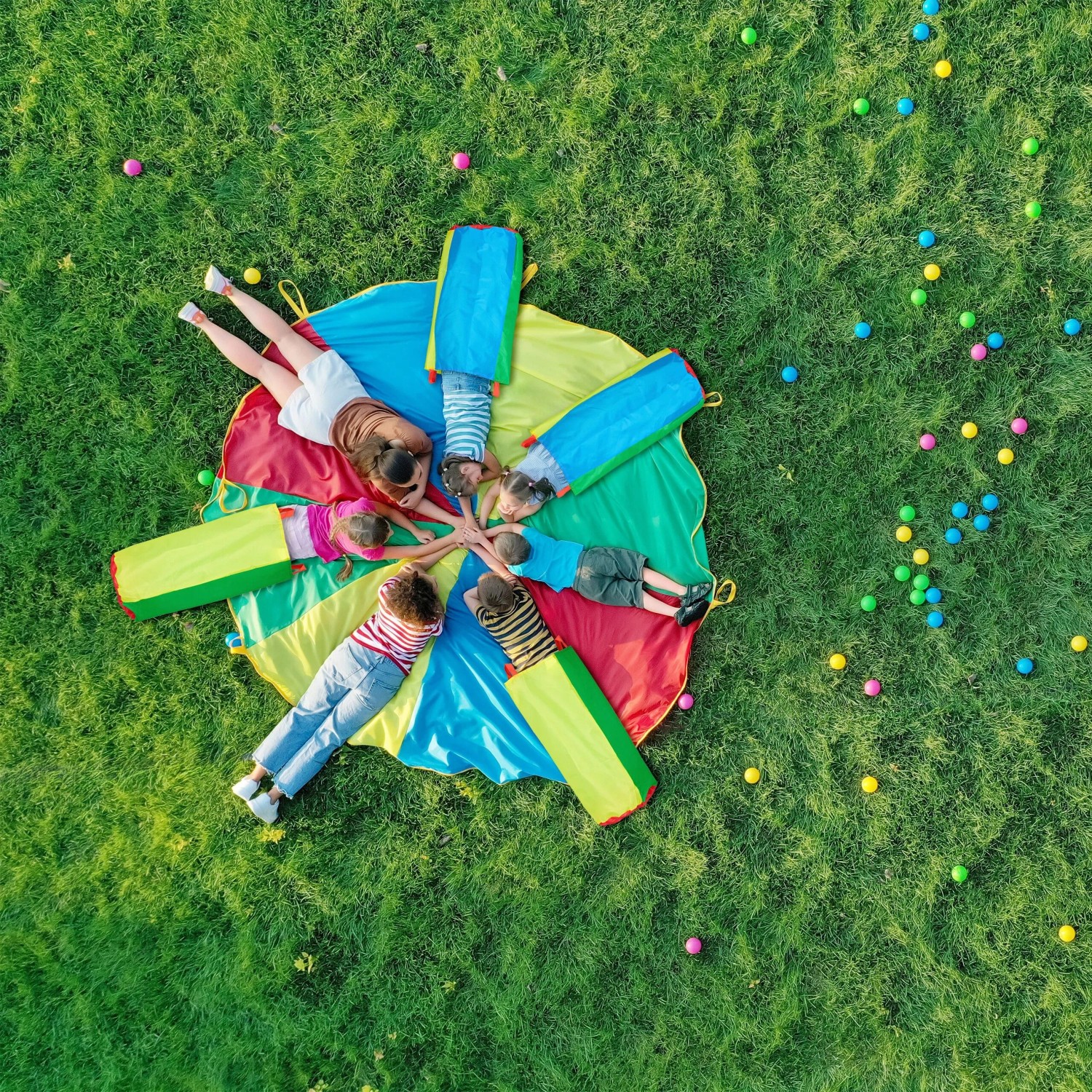 Mehrere Kinder spielen mit bunten Hüpfsäcken auf grünem Rasen. Fröhliches Outdoor-Spiel für Spiel & Spaß.