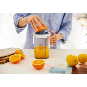 Rotho Messbecher Loft 1,5l: Frau presst Orange mit Zitruspresse Aufsatz. Küchenhelfer zum Backen.