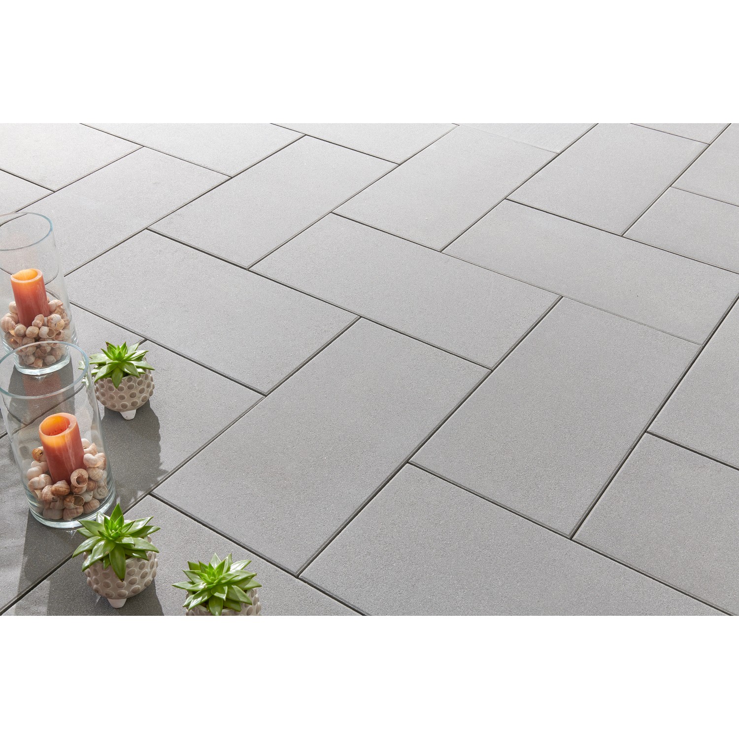 Verlegte, kugelgestrahlte, graue Terrassenplatten Casavera Maxx (80x40 cm) im Fischgrätmuster.