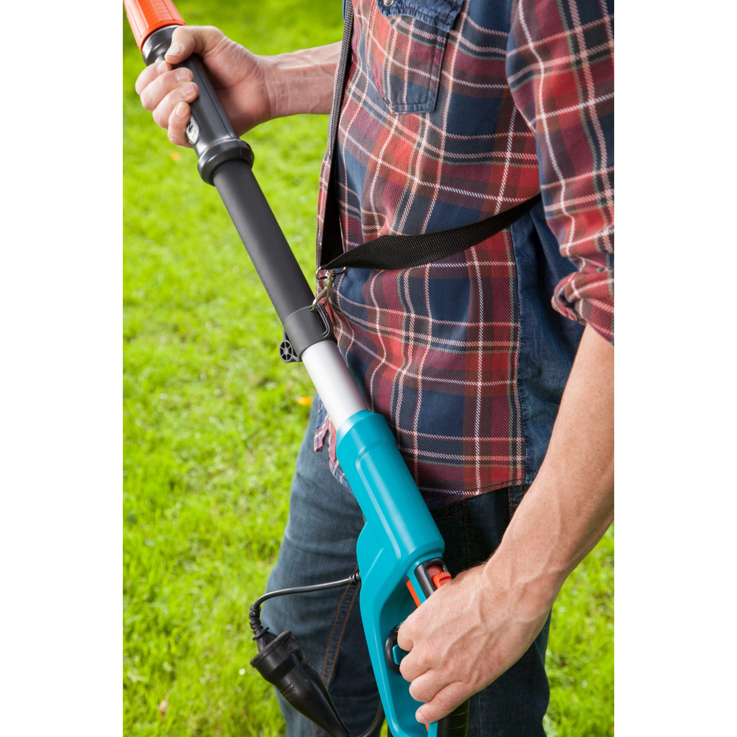 Gardena Elektro-Teleskopsäge TCS 720/20 mit Tragegurt in Anwendung.