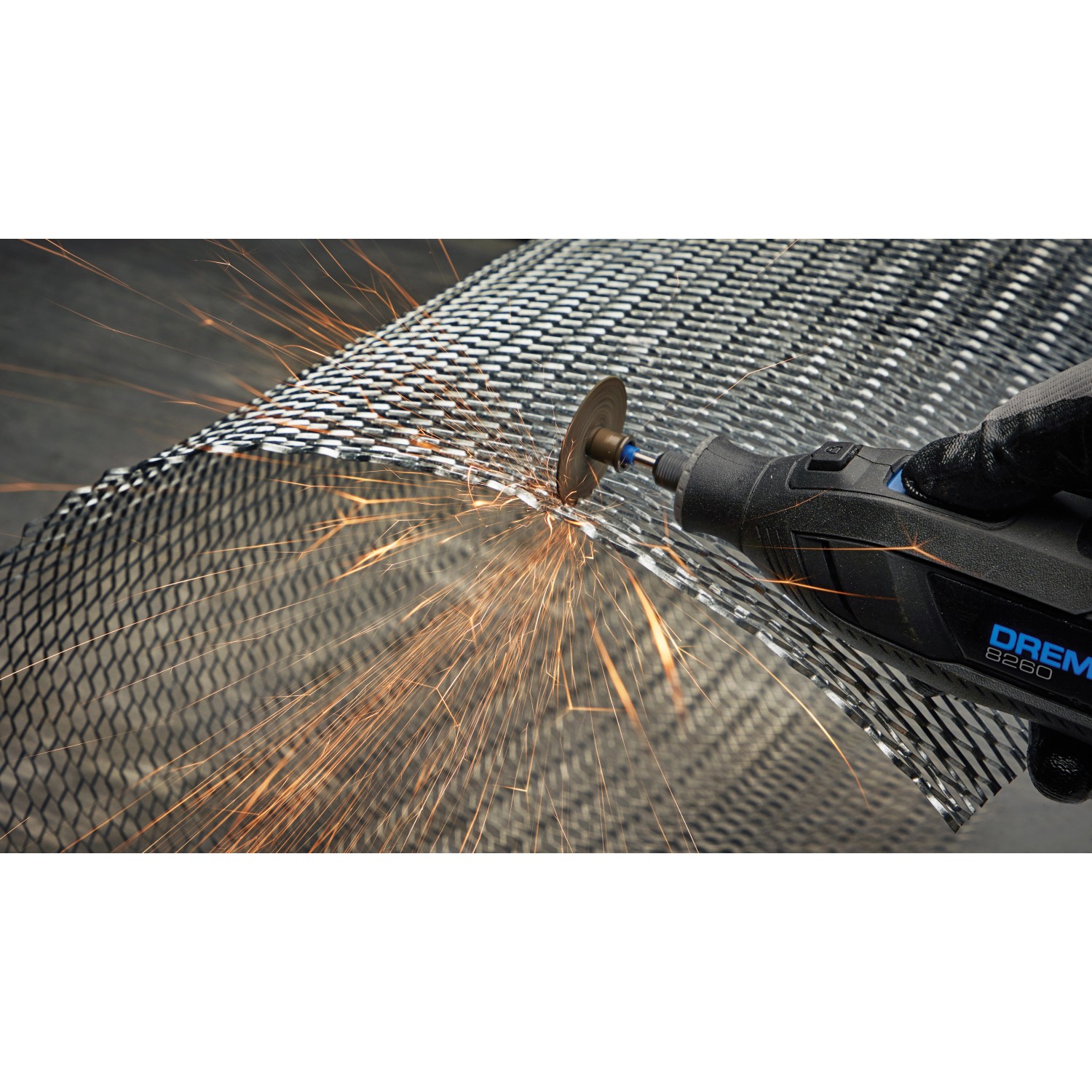 DREMEL® 8260 Multifunktionswerkzeug im Einsatz beim Schneiden von Metallgitter, Funken fliegen.