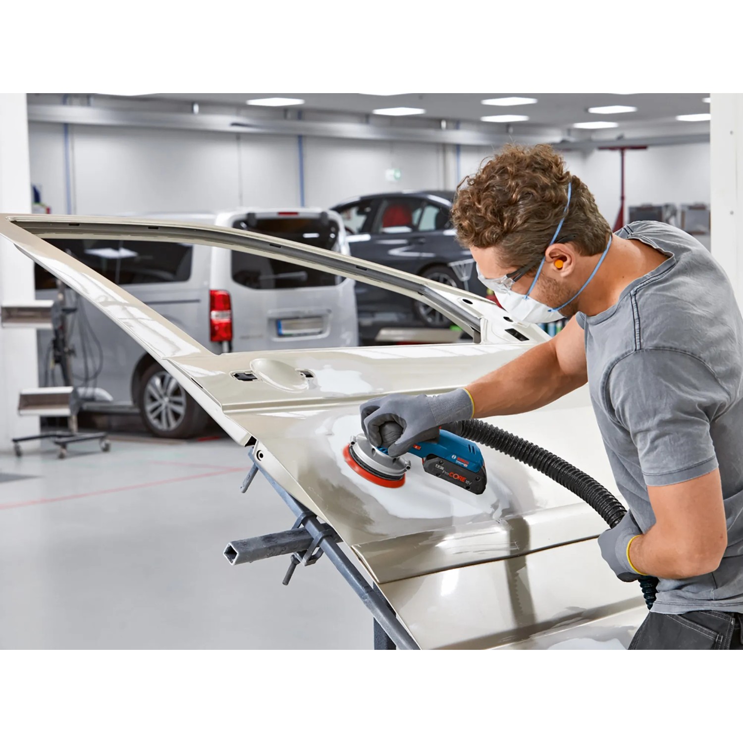 Bosch Akku-Exzenterschleifer GEX 18V-125 im Einsatz beim Schleifen einer Autotür.