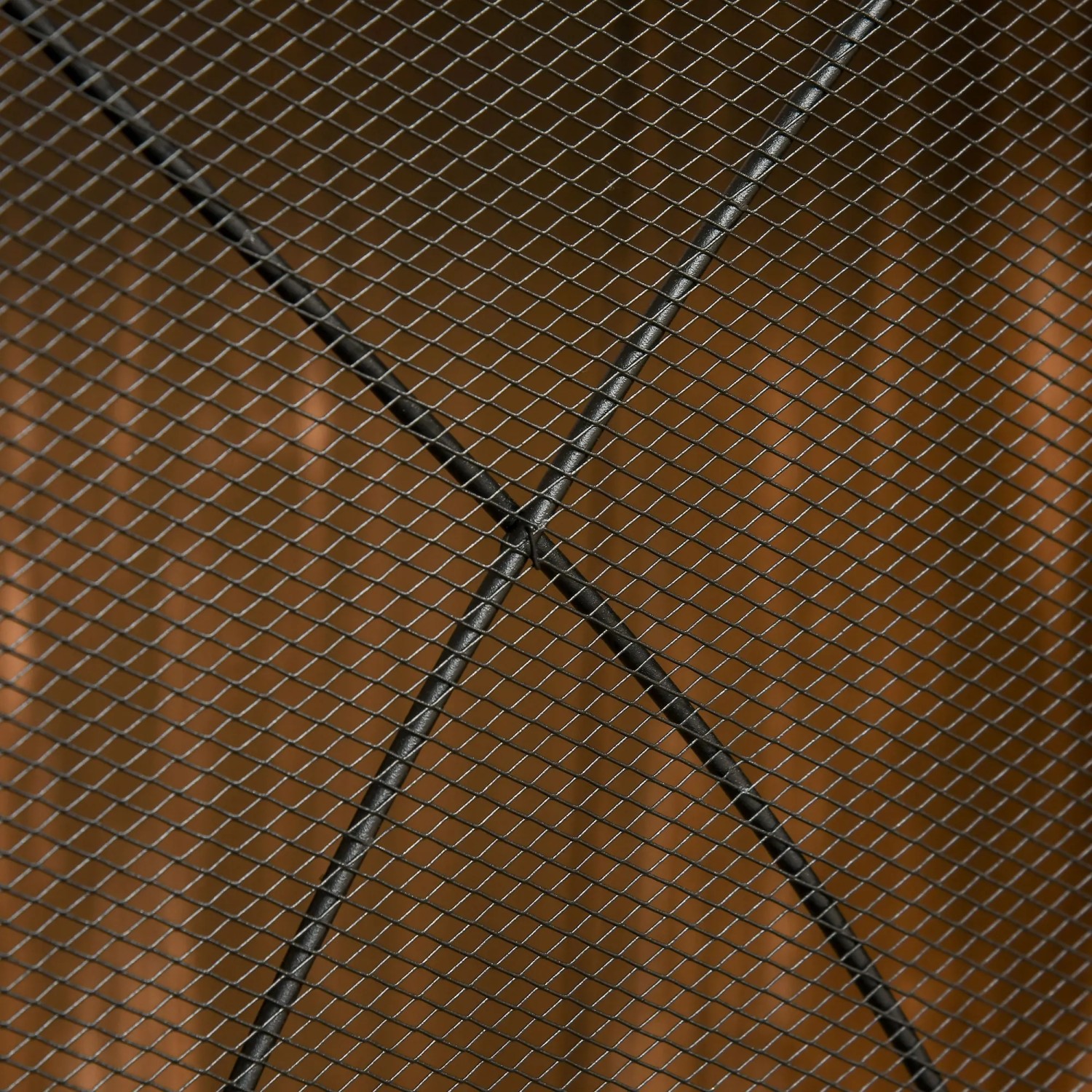 Detailansicht: Schwarzes HOMCOM Kaminschutzgitter aus Metall, Maschendraht vor braunem Hintergrund.