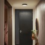 Schwarze Philips Hue Enrave S Deckenleuchte mit Dimmer im Flur.