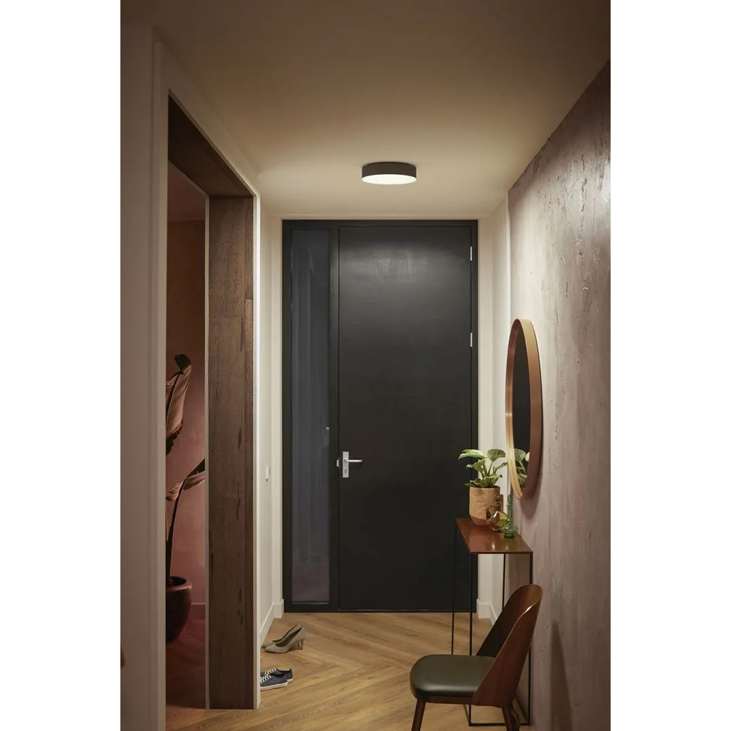 Schwarze Philips Hue Enrave S Deckenleuchte mit Dimmer im Flur.