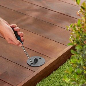 Montage der schwarzen Philips Hue Lily XL Außenleuchte auf einer Holzterrasse.