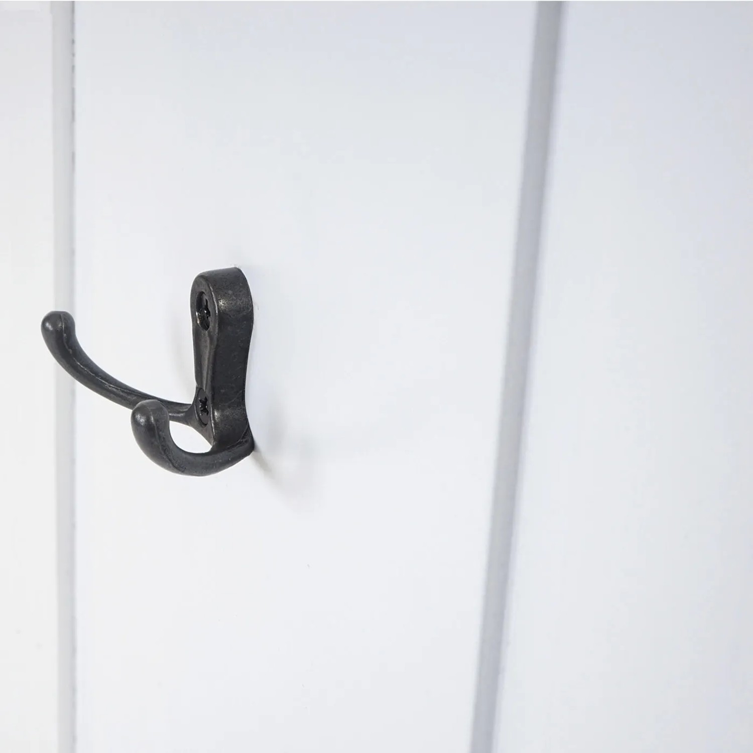 Detailaufnahme: Weiße MCW Wandgarderobe mit Metallhaken.