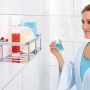 Verchromte Tesa Aluxx Duschablage mit Duschutensilien an weißer Wand.