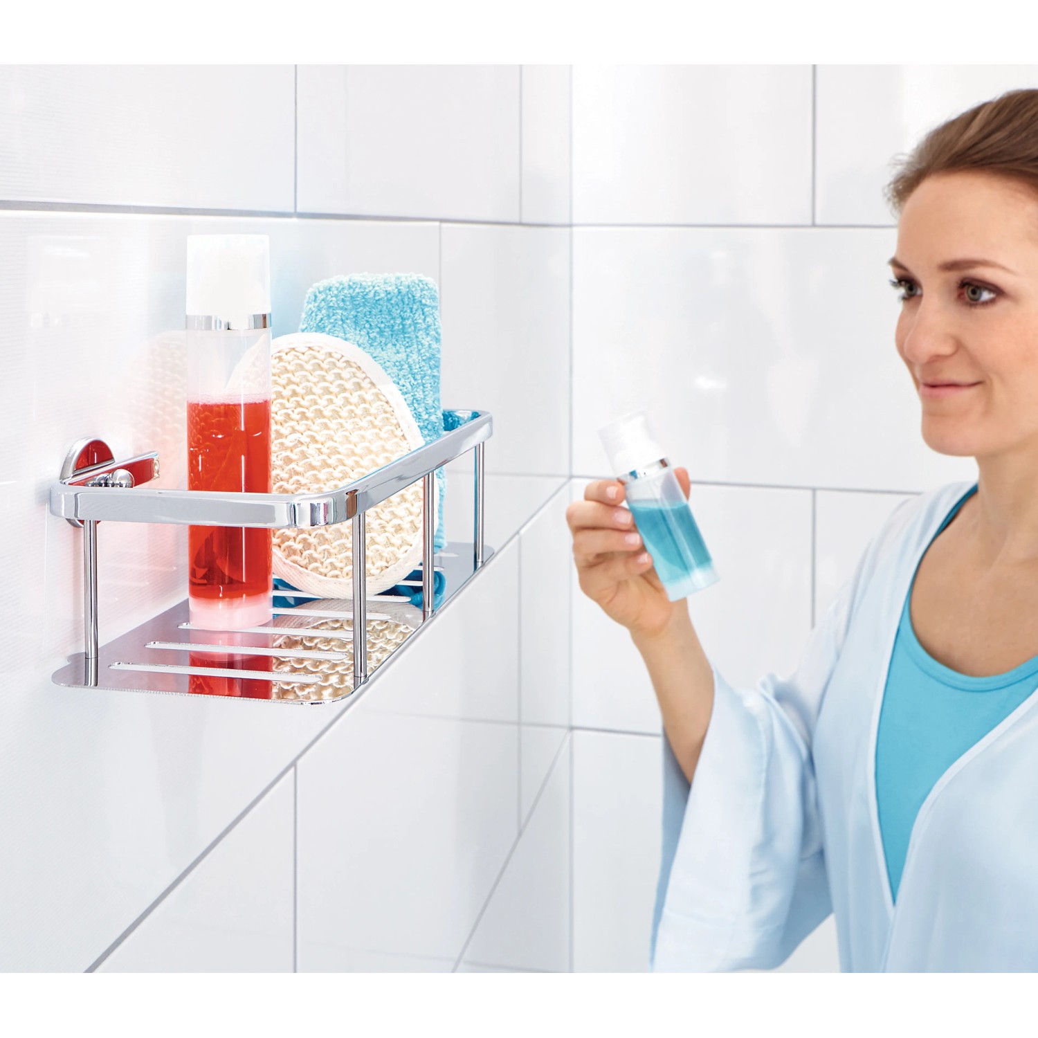 Verchromte Tesa Aluxx Duschablage mit Duschutensilien an weißer Wand.