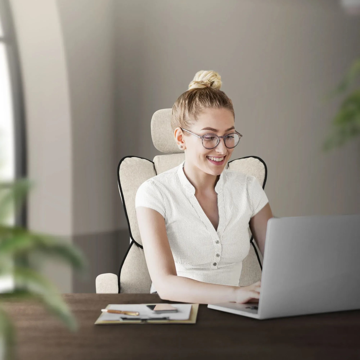 Frau sitzt auf beigem, ergonomischen ML-Design Bürostuhl mit verstellbarer Rückenlehne vor Laptop.