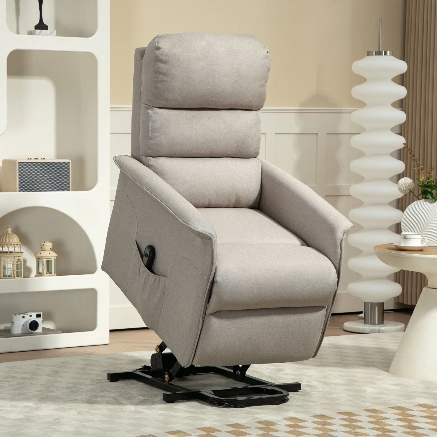 Beiger elektrischer Aufstehsessel aus Polyester, in leicht erhöhter Position. Fernbedienung in Seitentasche. Komfortabler Loungesessel.
