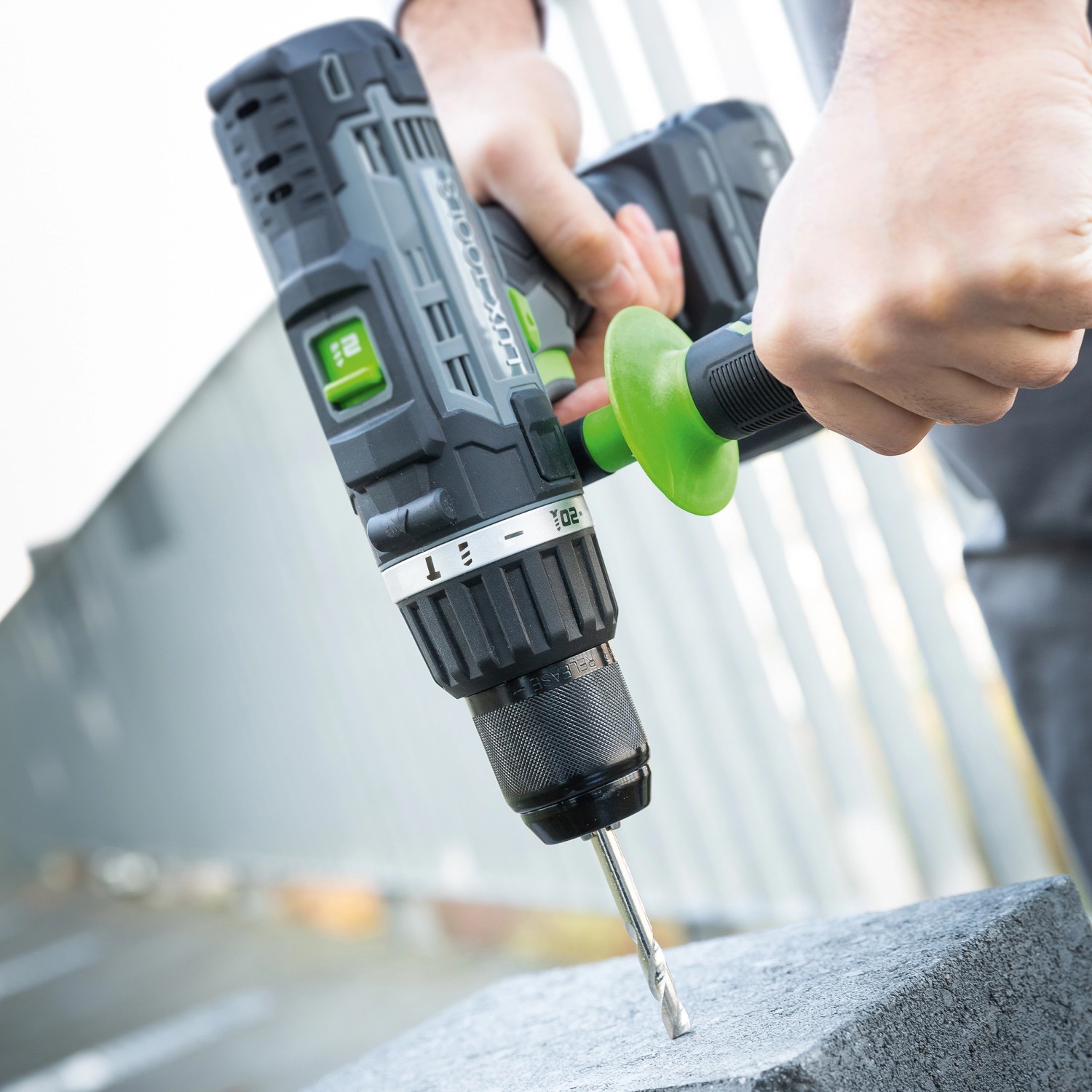 LUX Akku-Schlagbohrschrauber A-BS-20/S beim Bohren in Stein, mit Zusatzhandgriff.