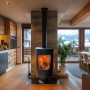 Schwarzer Sannover Holzofen Oscar 8,2 kW mit brennendem Feuer in modernem Wohnraum. Für Holzscheite bis 35 cm.