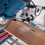 Bosch Professional GCM 305-216 D Kapp- und Gehrungssäge beim Sägen eines Holzstücks.