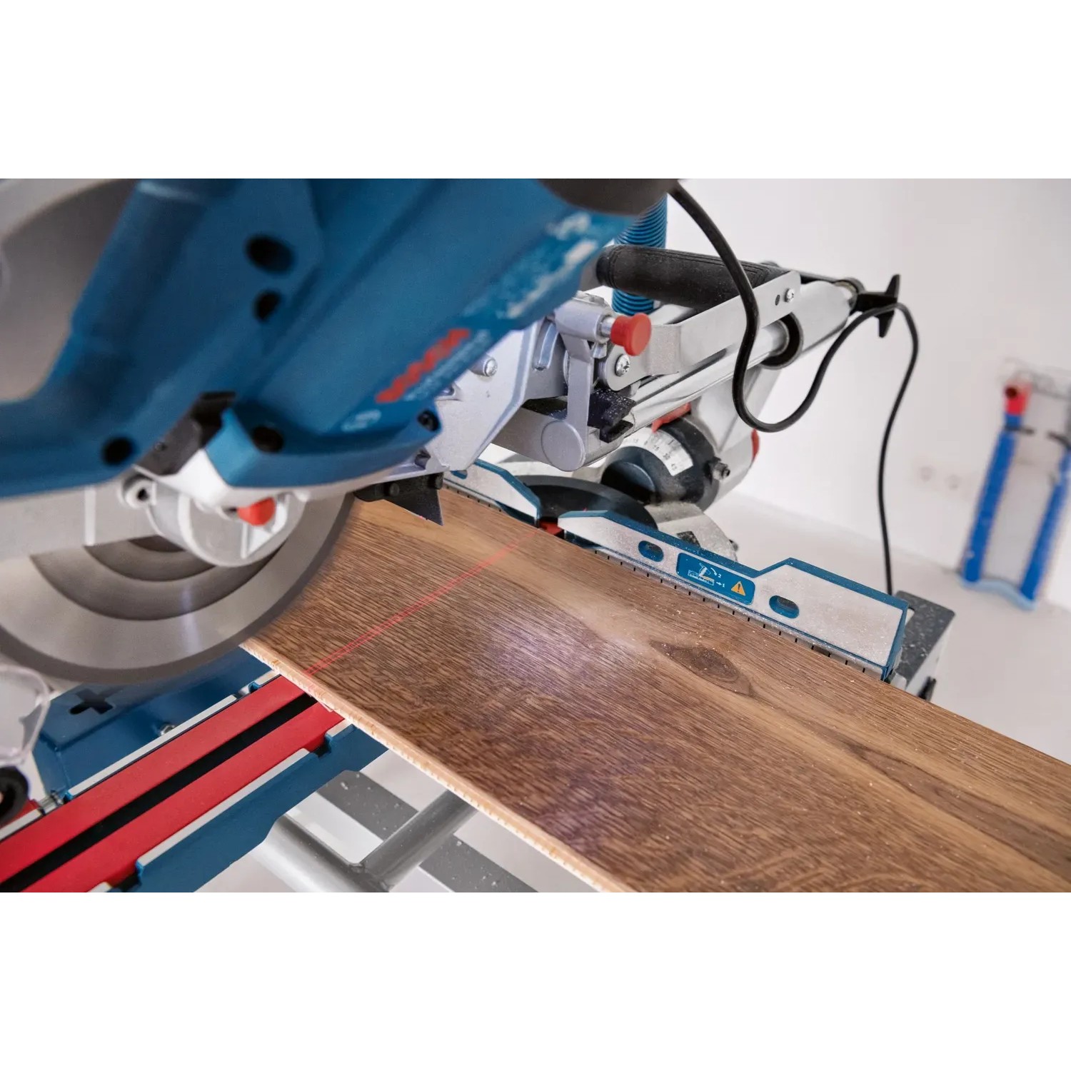 Bosch Professional GCM 305-216 D Kapp- und Gehrungssäge beim Sägen eines Holzstücks.