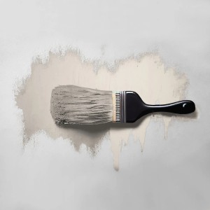 Pinsel streicht Tadessi Wandfarbe Pastell Cremeweiß matt auf Wand. Helle Dispersionsfarbe mit Tropfen.
