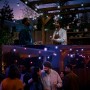 Philips Hue Festavia Globe Lichterkette (7 m) im Einsatz auf einer Gartenparty.