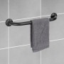 Schwarzer Wenko Badewannengriff Basic mit Handtuch an grauer Wand.