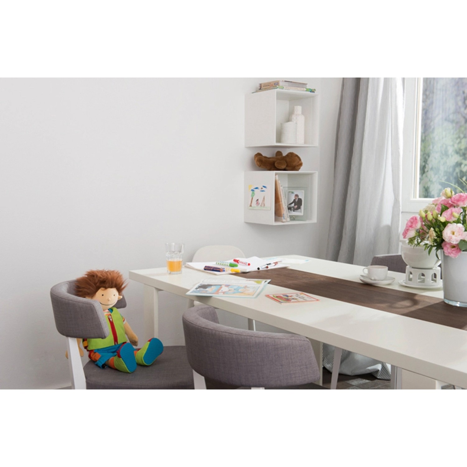 Szene mit Histor Clean Wandfarbe Weiß seidenmatt: Weißer Esstisch, Stühle, weiße Wand mit Regalen.