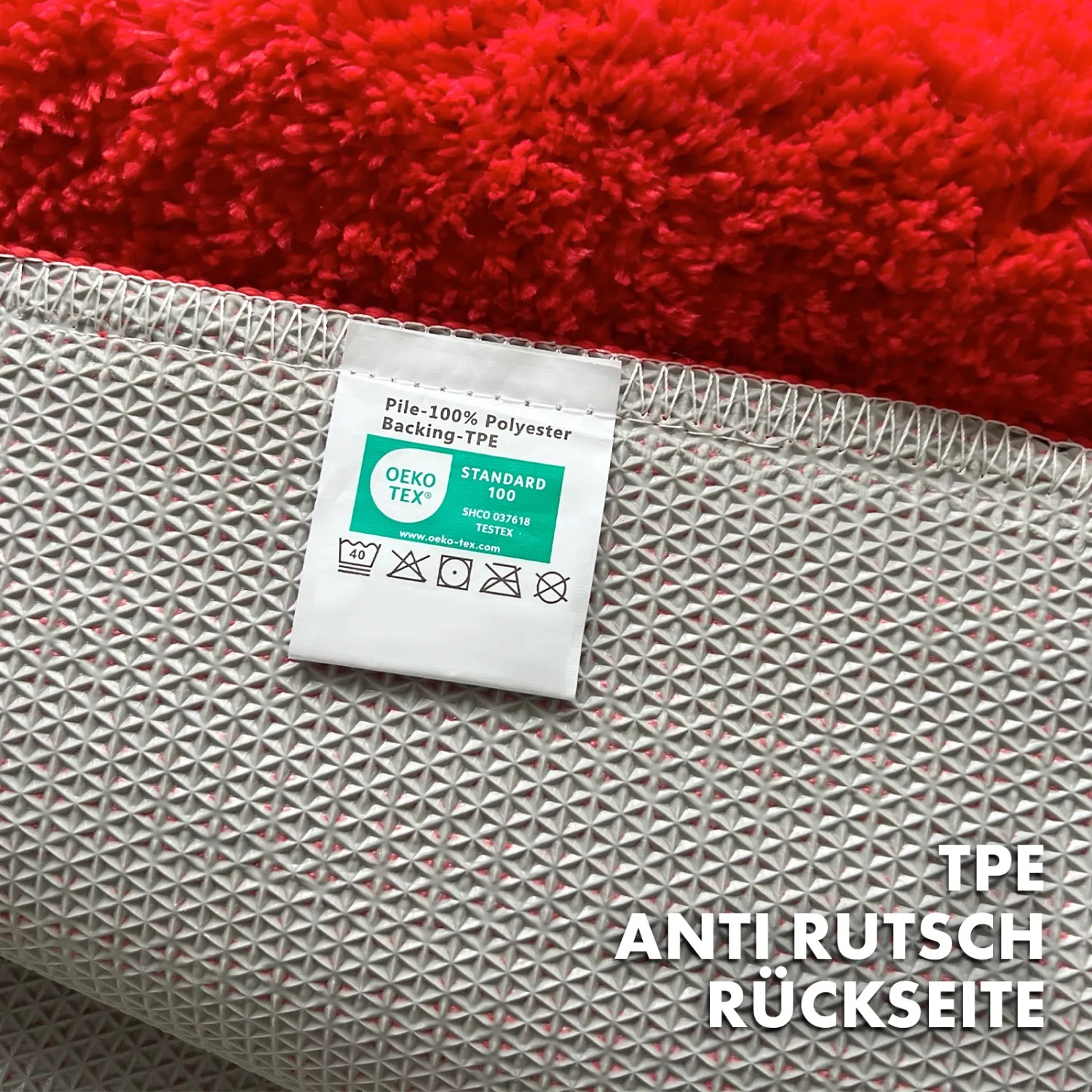 Rote Karat Badematte Maris, Rückseite mit Anti-Rutsch-Beschichtung und Pflegehinweis-Etikett.