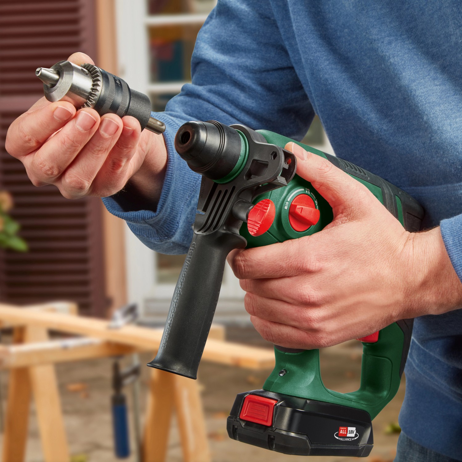 Bosch Akku-Bohrhammer UniversalHammer 18V mit Bohrfutter in der Hand, Akku-Bohrhammer grün/schwarz.