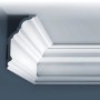 Weißes Orac Luxxus Eckleisten Musterstück, 10 cm, mit klassischem Zierprofil an Wand und Decke.