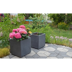 Anthrazitfarbener Ondis24 Pflanzkübel Vulkan 50 in Schieferoptik mit Bepflanzung im Garten.