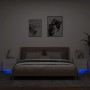Zwei weiße Wand-Nachttische mit LED-Beleuchtung unter einem Bett.