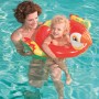 Kind mit rotem Bestway Schwimmring im Tierdesign (Papagei) im Pool, gehalten von einer Frau.