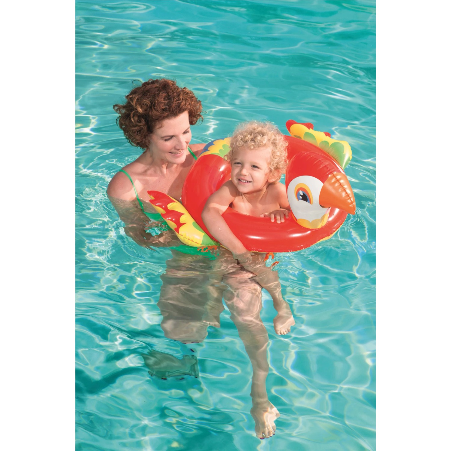 Kind mit rotem Bestway Schwimmring im Tierdesign (Papagei) im Pool, gehalten von einer Frau.