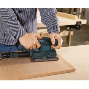 Schwingschleifer mit LUX Schleifvlies Set im Einsatz auf Holzoberfläche.