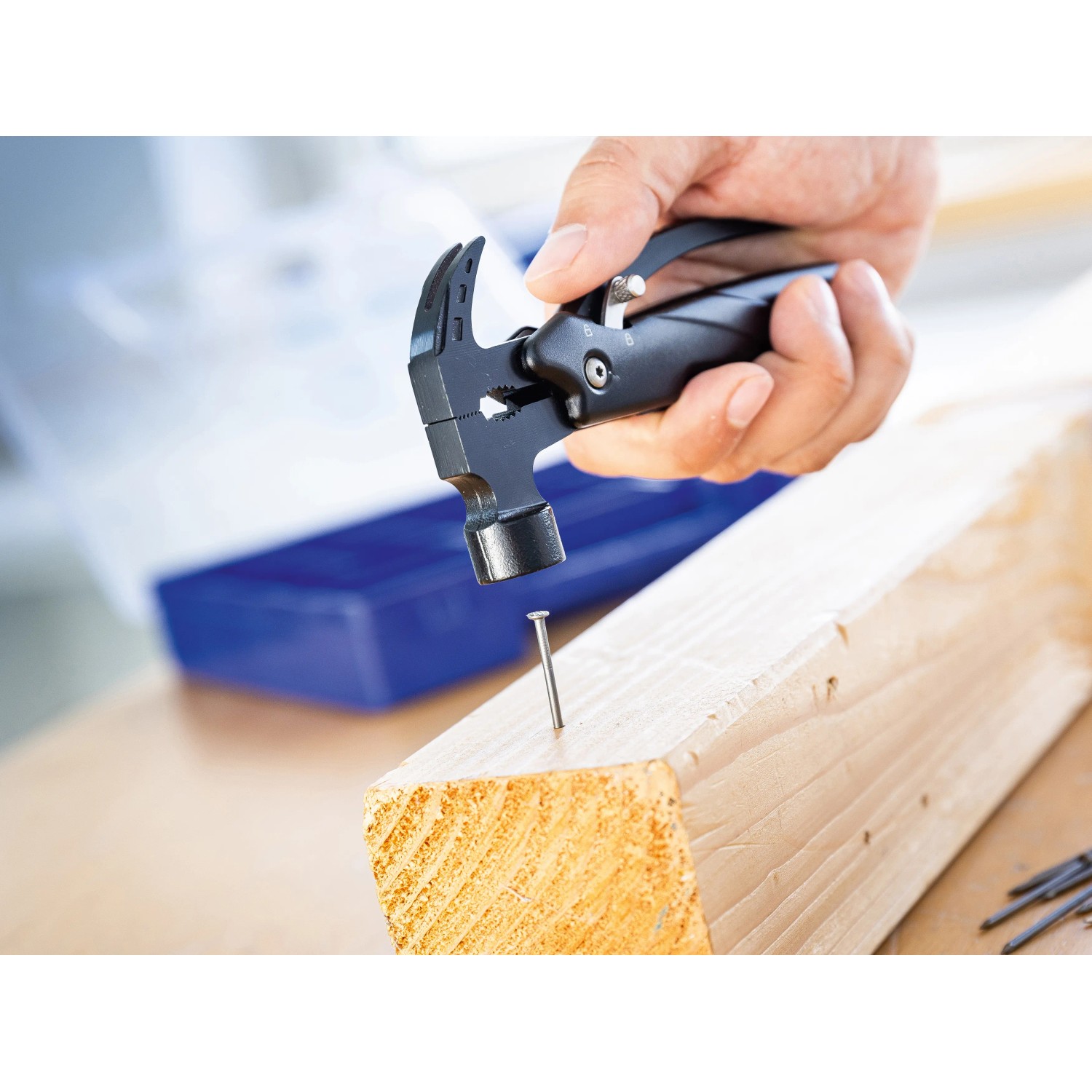 LUX Multi-Tool Hammer Messer beim Einschlagen eines Nagels in Holz.