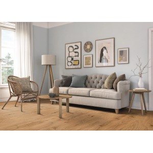 Wohnraum mit hellem Parkettboden. Gemütliches Ambiente mit Sofa, Sessel und Dekoration.