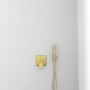 Ideal Standard Brausehalter Idealrain Atelier eckig in Gold an weißer Wand.