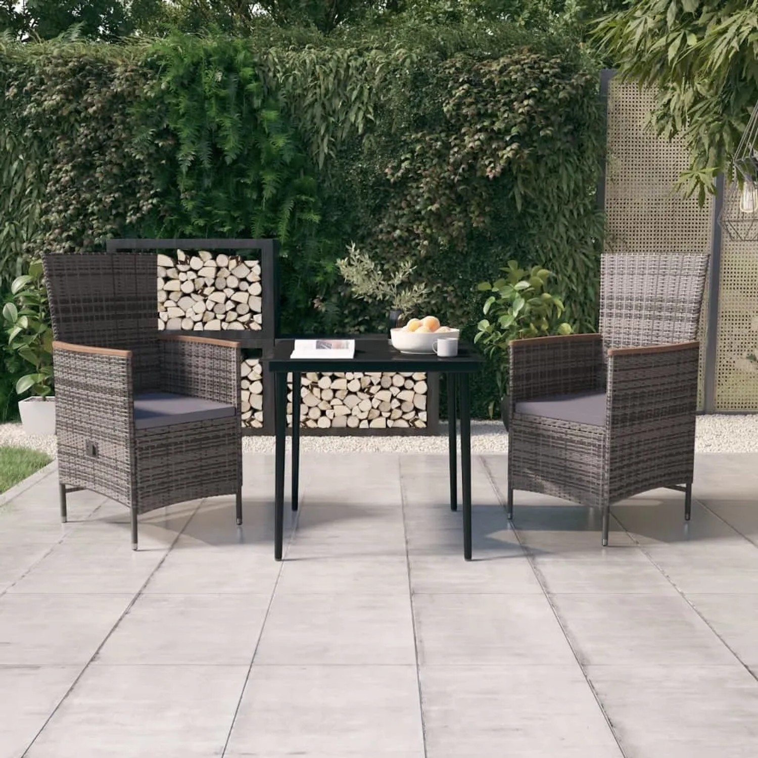 Graue 3-tlg. Garten Essgruppe mit Rattanstühlen, Tisch mit Glasplatte und dunklen Kissen.