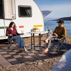 Anthrazitfarbene Skaza Terrassenplatten auf Balkon/Terrasse mit sitzenden Personen vor Wohnwagen.