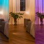 Philips Hue Wandschalter Modul in Weiß zeigt verschiedene Lichtszenen im Wohnraum.