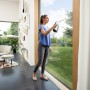Frau reinigt Fenster mit Kärcher Akku-Fensterreiniger WV 6 Plus P in Weiß-Schwarz.